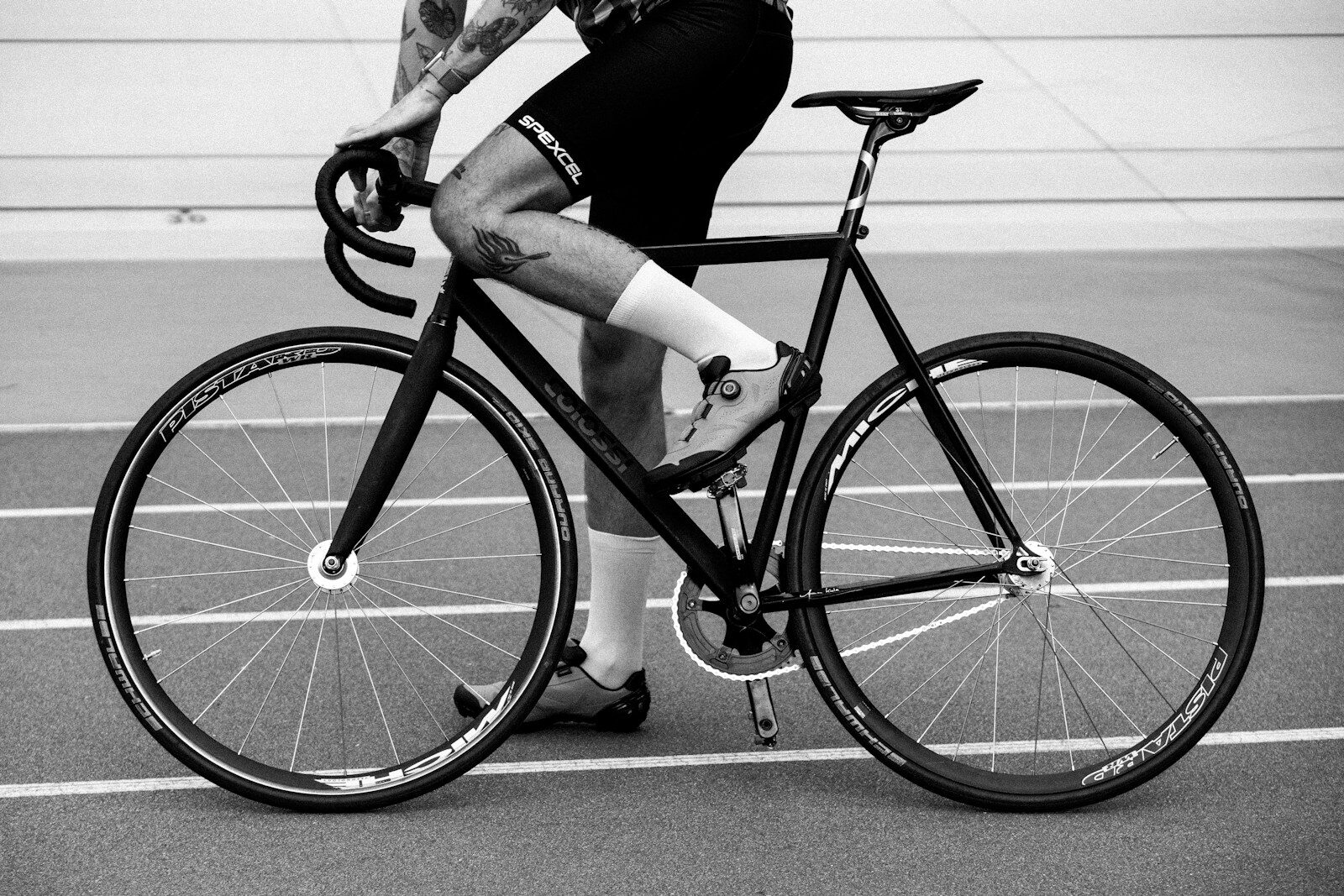 Cyclist riding on a track with a fixed gear bike.
