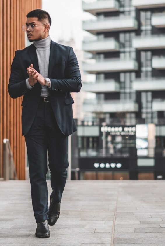 Photo by Jeff Tumale man in black suit standing on sidewalk during daytime